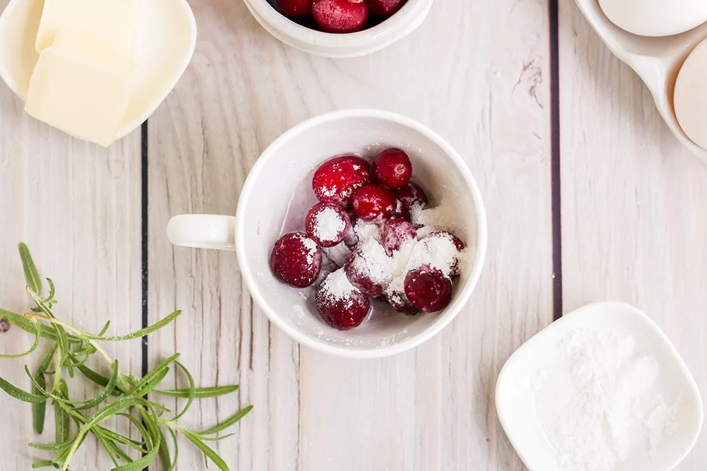 Cranberries and sweetener in a mug.