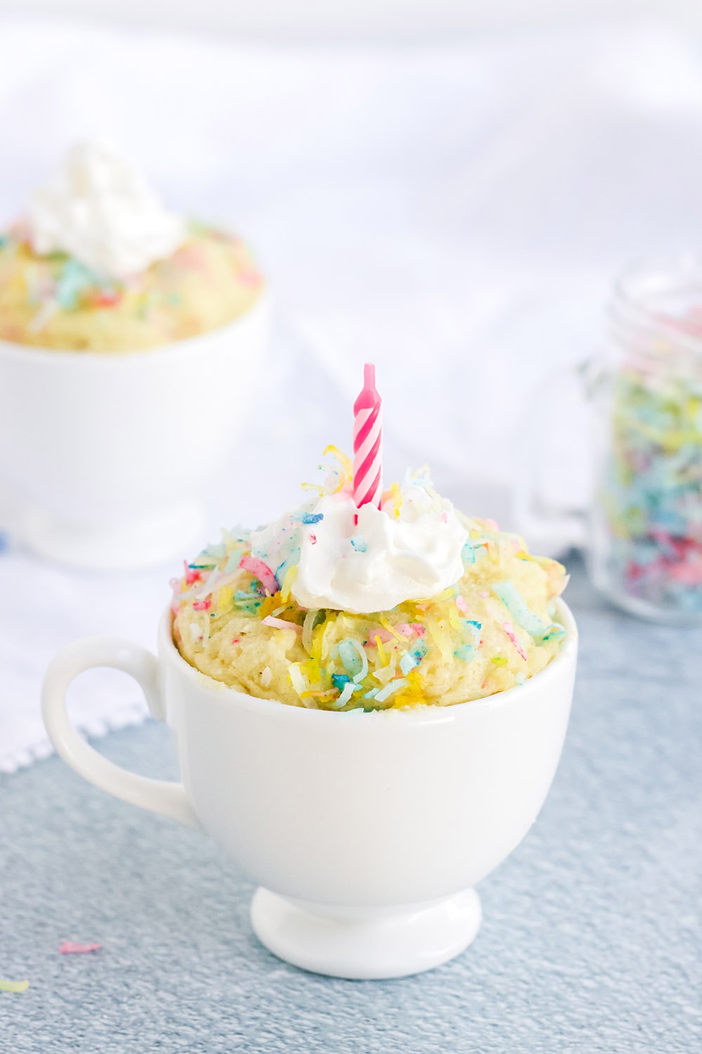 Keto birthday cake in a mug with a candle.