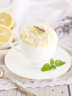 lemon cake in a mug with lemons and lavender around on the table