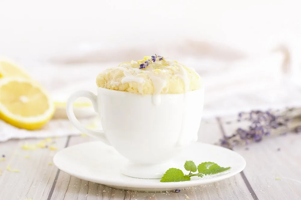 Lemon cake in a white mug topped with lavender.