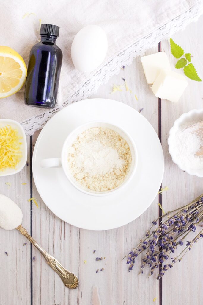 dry ingredients in mug with dried lavender, lemon, and other ingredients on table