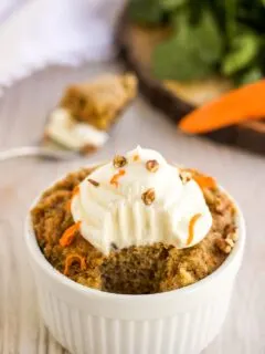 Carrot cake with a bite missing and fork in the background