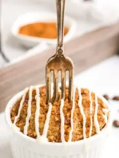 Fork in a coffee cake mug cake topped with glaze