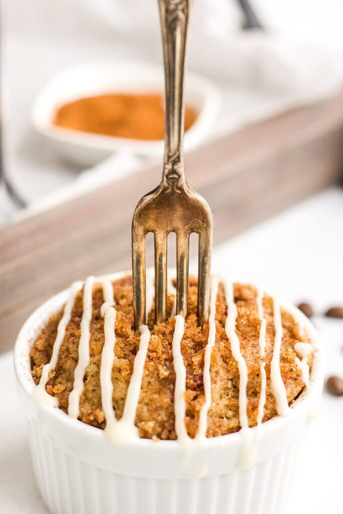 Fork in a coffee cake mug cake topped with glaze