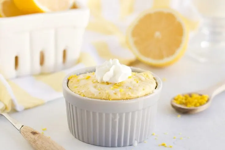 Lemon cake in a ramekin topped with whipped cream.