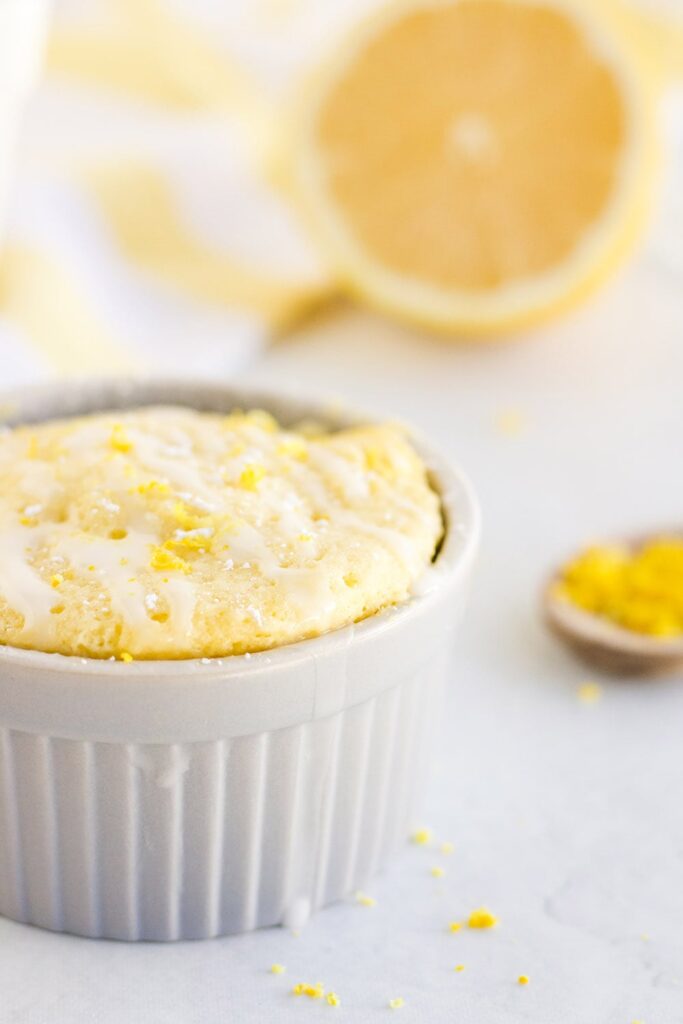 Lemon cake in a mug topped with lemon zest. 