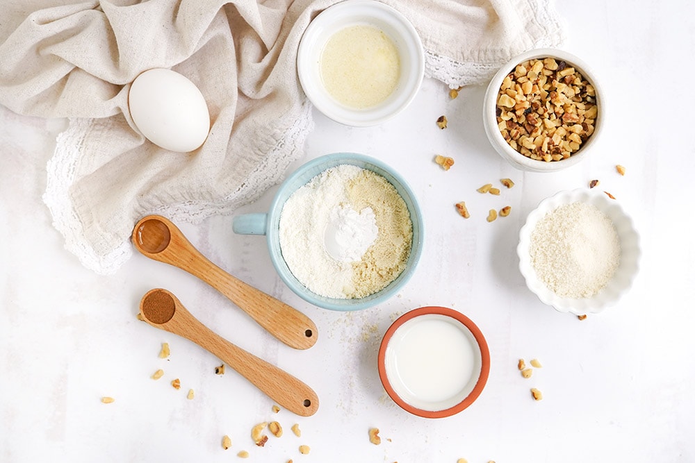 Bowls of ingredients to make a keto banana mug cake on a table.