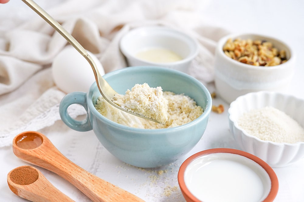 Dry ingredients in a light blue mug for banana cake.