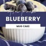Mug cake topped with blueberries sitting on a blue and white napkin.