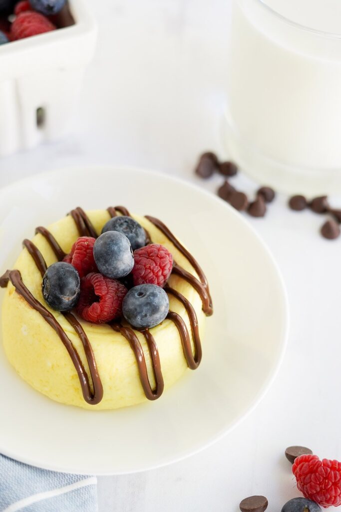 Cheesecake on a plate with berries and chocolate around.