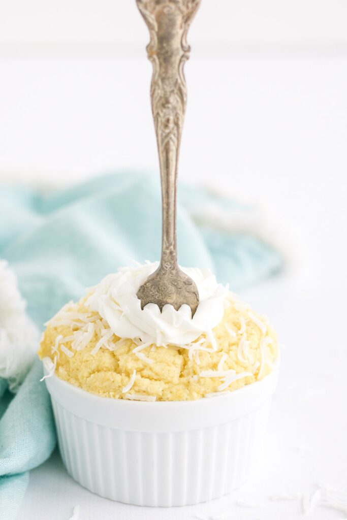 Fork in a yellow cake in a tiny white dish.
