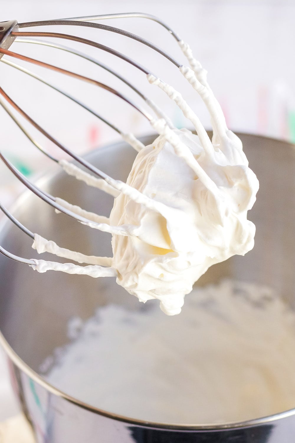Whisk attachment with whipped cream on it.