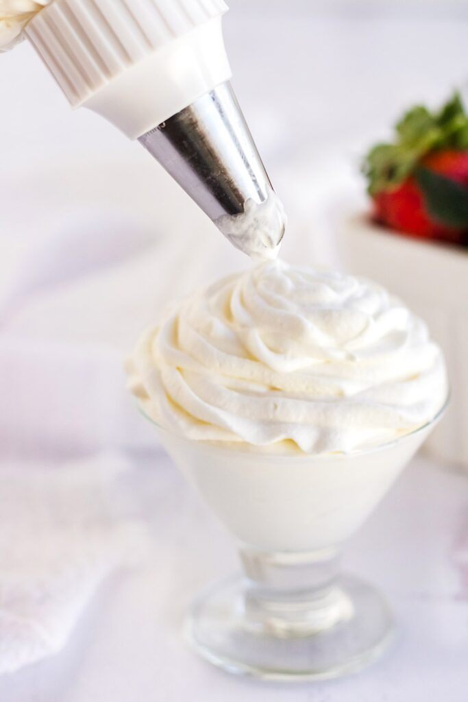 Piping whipped cream into a glass.